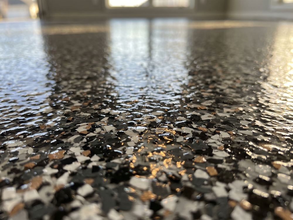 Close-up of decorative vinyl flake broadcast sealed under a clear polyaspartic topcoat