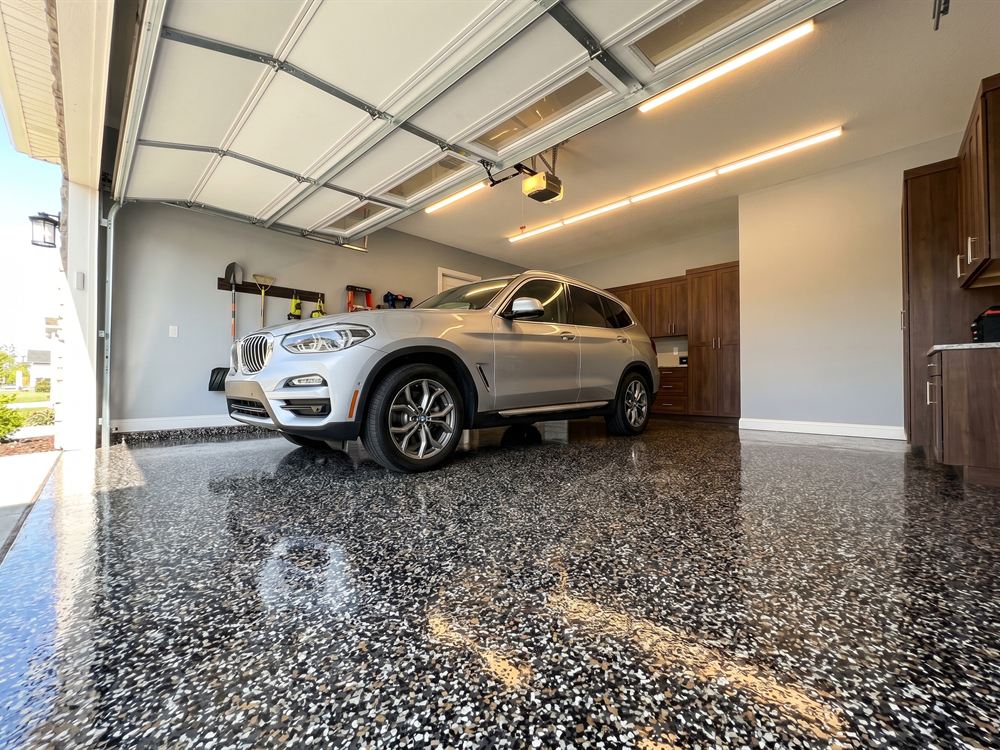 Silver SUV parked on a dark flake polyaspartic garage floor